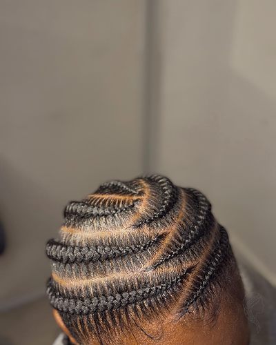 Stitch feed-in cornrows with a swirled crown and clean parting